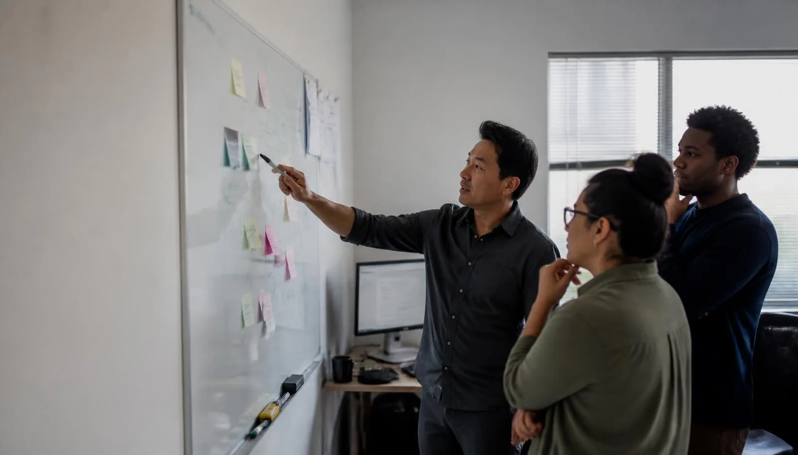 A small services team mapping a delivery plan on a whiteboard during a working session.